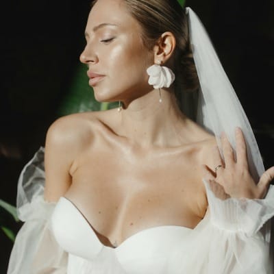 Braut mit Schleier und großen Brautohrringen mit Stoff-Blüten