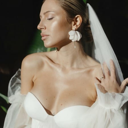 Braut mit Schleier und großen Brautohrringen mit Stoff-Blüten
