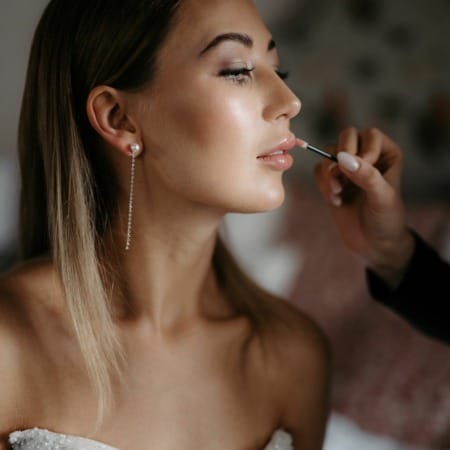 Braut wird geswchminkt und trägt Brautohrringe